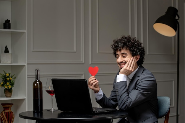 Virtual love handsome cute guy in suit with wine on a distance computer date holding face