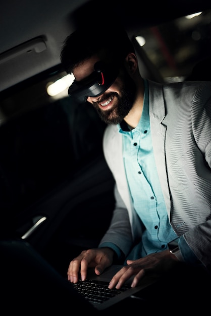 Virtual reality concept. Businessman in the car working late.