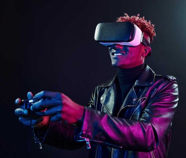 Virtual reality experience Futuristic neon lighting Young african american man in the studio