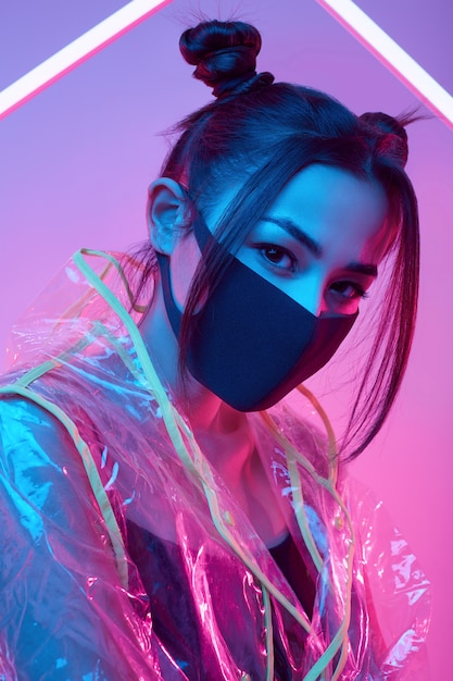 Virus mask Asian woman wearing face protection around colorful neon