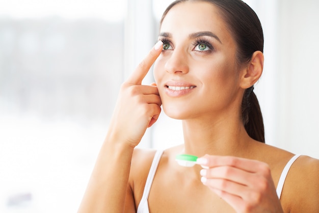 Vision concept. Close-up shot of young woman wearing contact lens