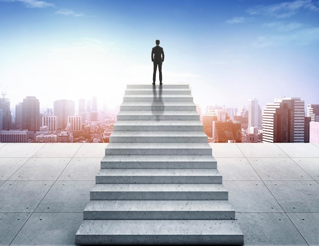 Vision concept Successful businessman standing on staircase and