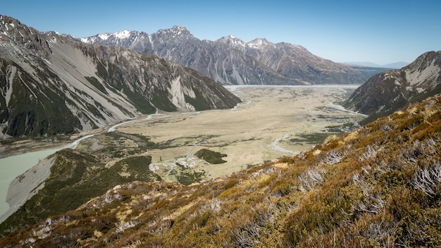 vista on alpine valley with dry tussocks in foreground shot at new zealand