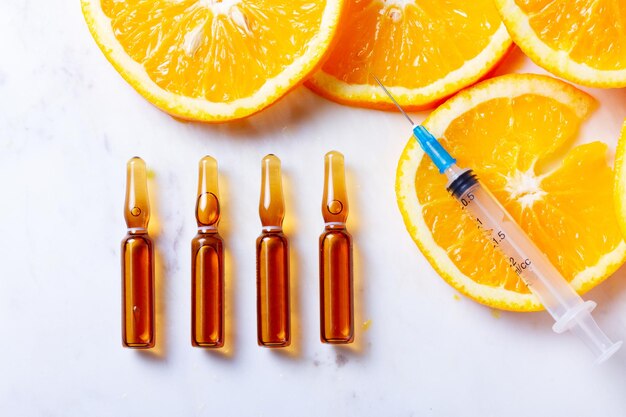 Vitamin C natural anti aging cosmetics serum ampullas and syringe