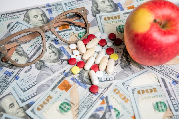 Vitamins of medicine expenses closeup with apple photo of medicine expenses currency