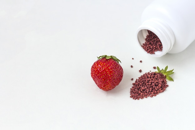 Vitamins supplements as a capsule with berries from medicine jar.