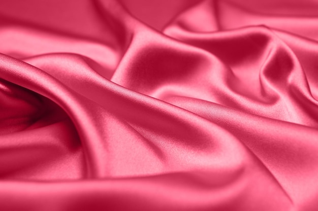 Viva Magenta toned red magenta fabric atlas. Close up pink silk satin texture for sewing