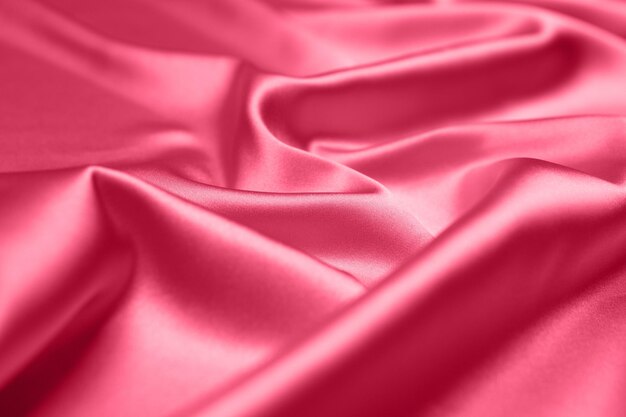 Viva Magenta toned red magenta fabric atlas. Close up pink silk satin texture for sewing