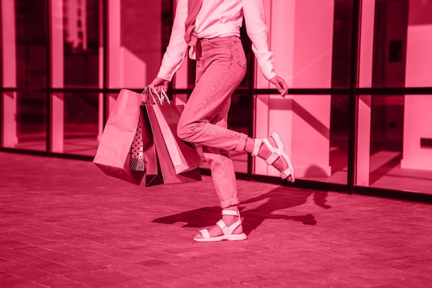 Viva Meganta toned red magenta european woman hold bags after shopping, retail store mall