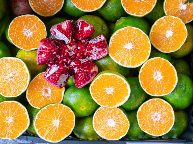 Vivid large peeled pomegranate among cutted oranges