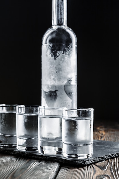 Vodka in shot glasses on rustic wood background