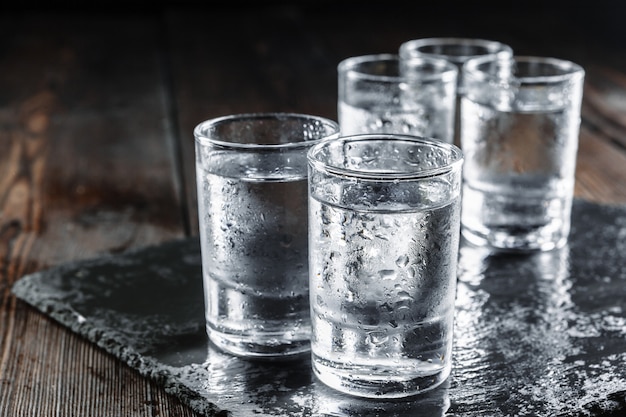 Vodka in shot glasses on rustic wood 