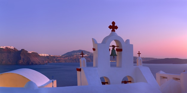 Volcanic caldera on Santorini island over the bell tower of the local church in Oia, Santorini