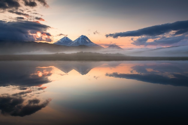 Volcanoes and their reflections in the lake at sunrise in Kamchatka Russia