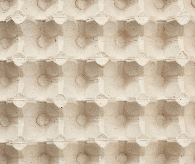 Volumetric texture of a beige paper egg tray