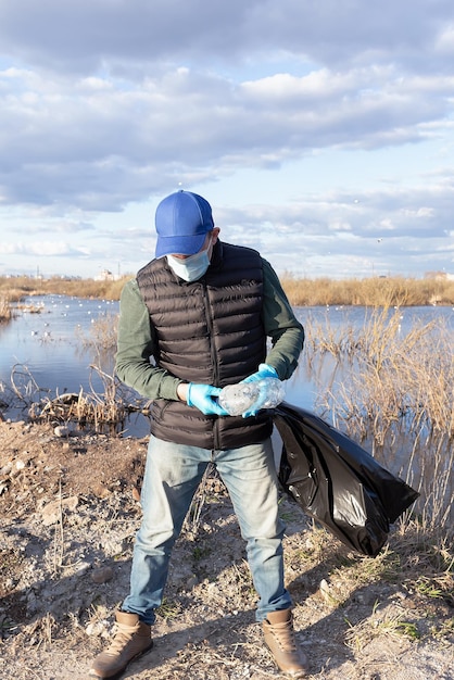 A volunteer collects empty plastic bottles Ecology and the environment