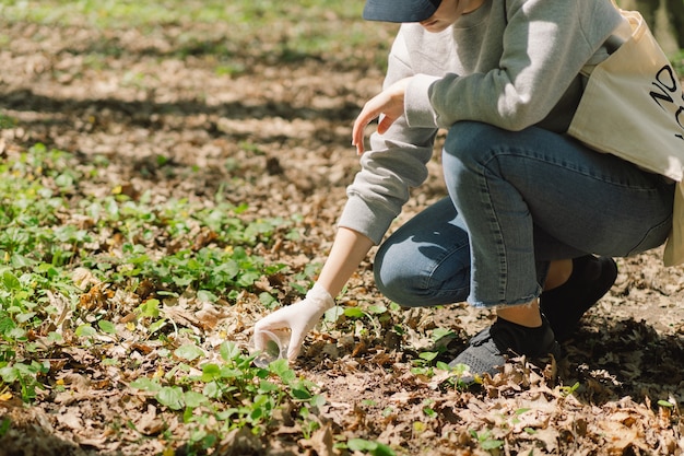 Volunteer woman is cleansed in the forest woman collects plastic