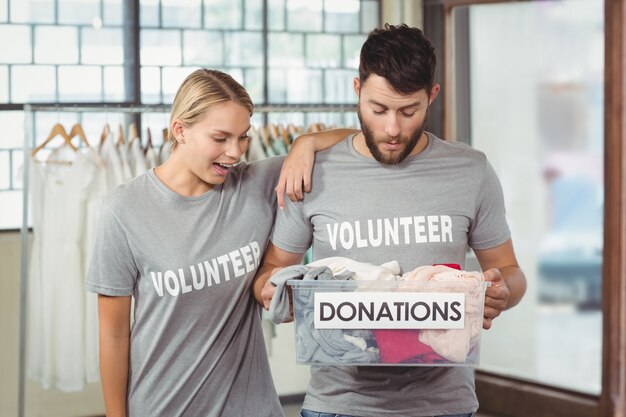 Volunteers looking at clothes in box