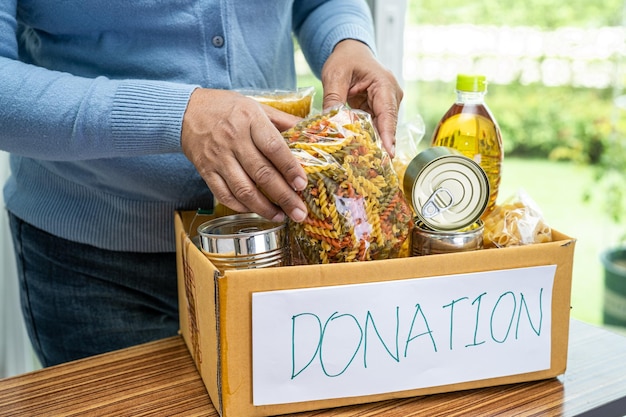 Volunteers putting various dry food in donation box for help people