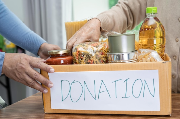 Volunteers putting various dry food in donation box for help people