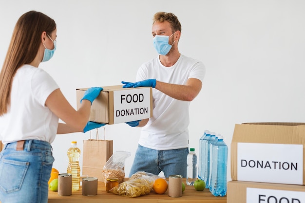 Volunteers with gloves and medical masks getting donation boxes ready