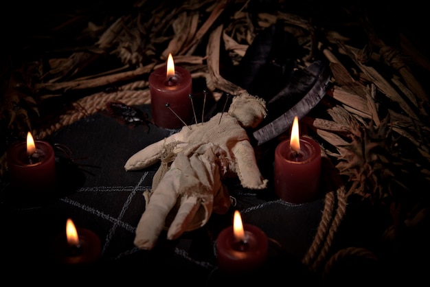 Voodoo doll black candles pentagram and old books on witch table Occult esoteric divination and wicca concept Mystic voodoo and vintage background