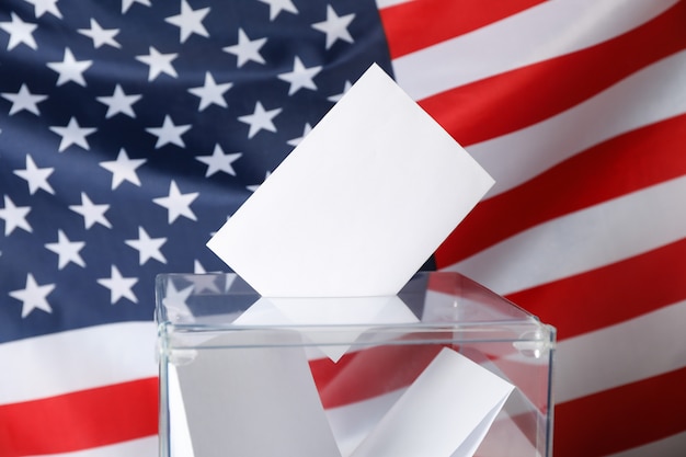 Voting box with bulletins on American flag