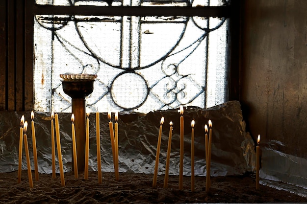 Votive candles in sand in a greek orthodox church Athens Greece