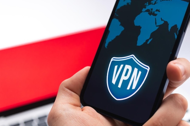 Photo vpn in poland secure and safe internet concept privacy hand with mobile phone and vpn application flag and laptop on the background photo