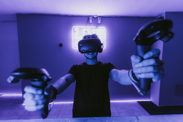 Vr esports the guy is playing an online shooter in the game neon room high quality photo