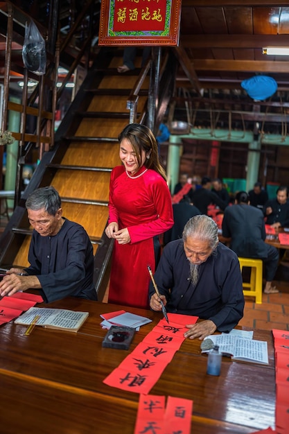 Vung Tau Vietnam JAN 12 2023 Vietnamese scholar writes calligraphy at Long Son Calligraphy festival is a popular tradition during Tet holiday Writing couplets for Spring Festival new year