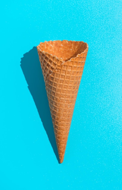 Waffle ice cream cone on a blue background Top view vertical