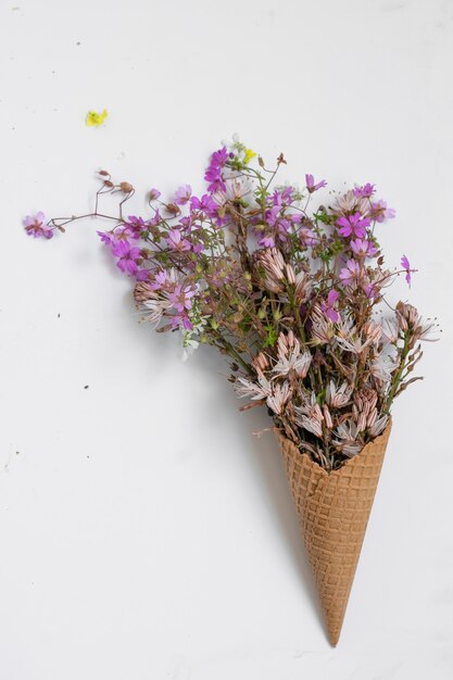 Waffle ice cream cone filled with fresh blossom wild flowers