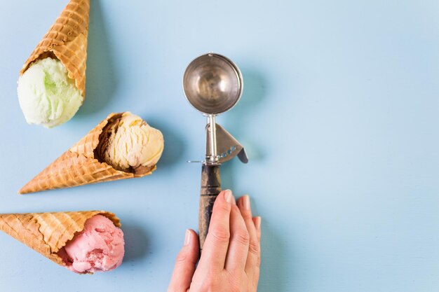 Waffle ice cream cones with scoops of ice cream on a blue background.