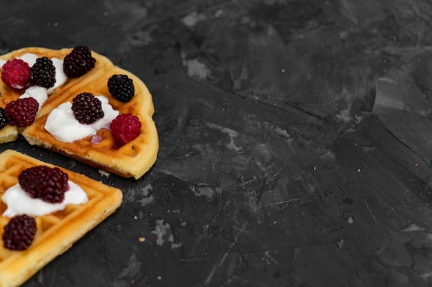 Waffles with cream on a dark gray background