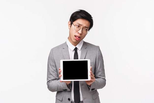 Waist-up portrait of bored reluctant and sad young asian man feeling tired and uninterested