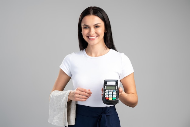 Waist up portrait view of the friendly caucasian waiter giving payment terminal to the customer can pay with credit card. Contactless payment concept