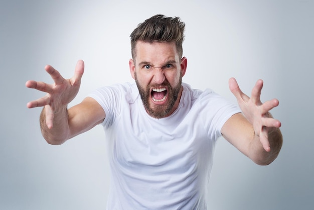 Wait till I get my hands on you Portrait of an angry young man losing his temper in studio