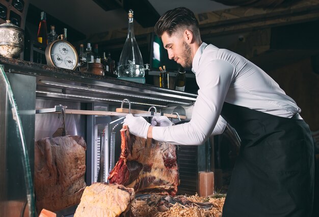 Photo the waiter or cook gets dry meat in the refrigerator.