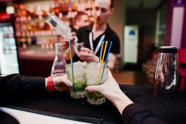 Waiter hands holding mojito coctails drink background bar man at work