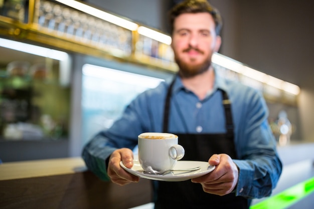 Waiter holding cup of coffee