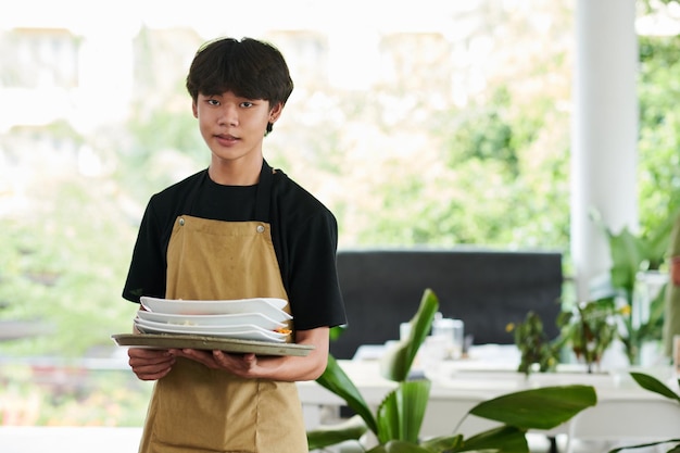 Waiter Holding Pile of Dirty Plates