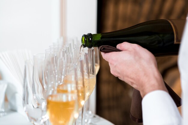 Waiter pours champagne. row of glasses at the celebration