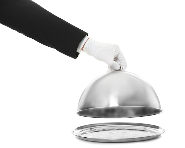 Waiter's hand holding cloche over tray against white background