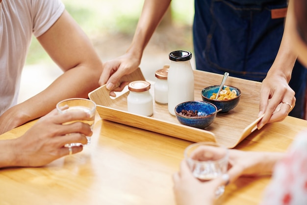 Waiter serving breakfast for young couple