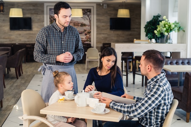 Waiter serving a family in a restaurant