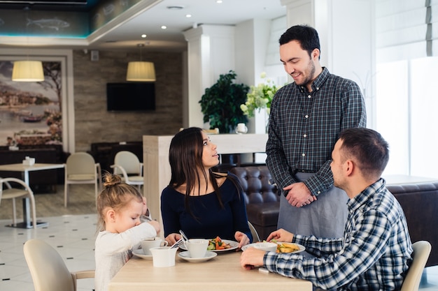 Waiter serving a family in a restaurant