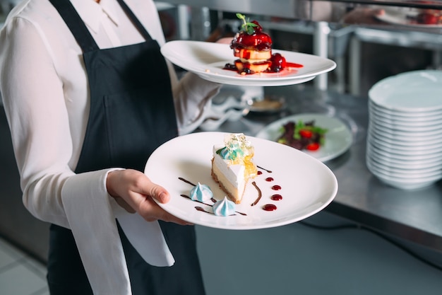 Photo waiter serving in motion on duty in restaurant. the waiter carries dishes.