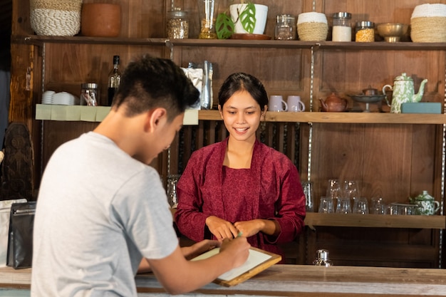 Waiter shows the menu to the customer