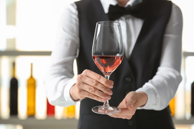 Waiter with glass of wine in bar